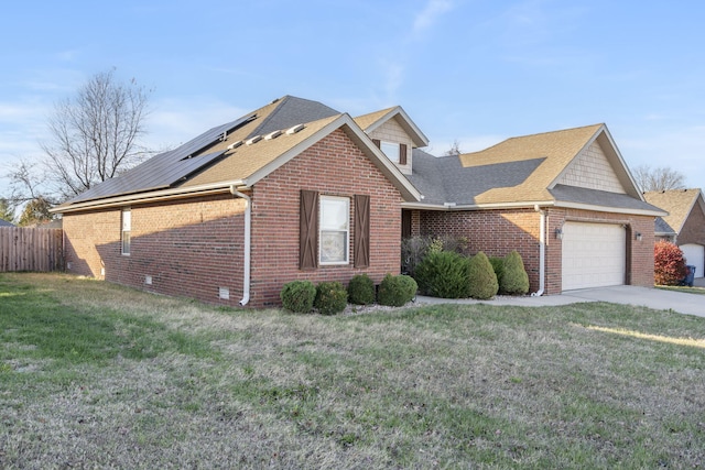 view of front of property with solar panels, a front lawn, and a garage