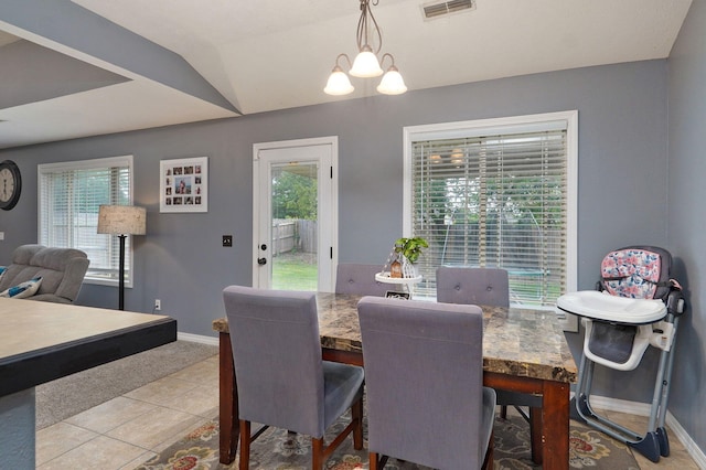 dining area featuring light tile patterned floors, lofted ceiling, and an inviting chandelier