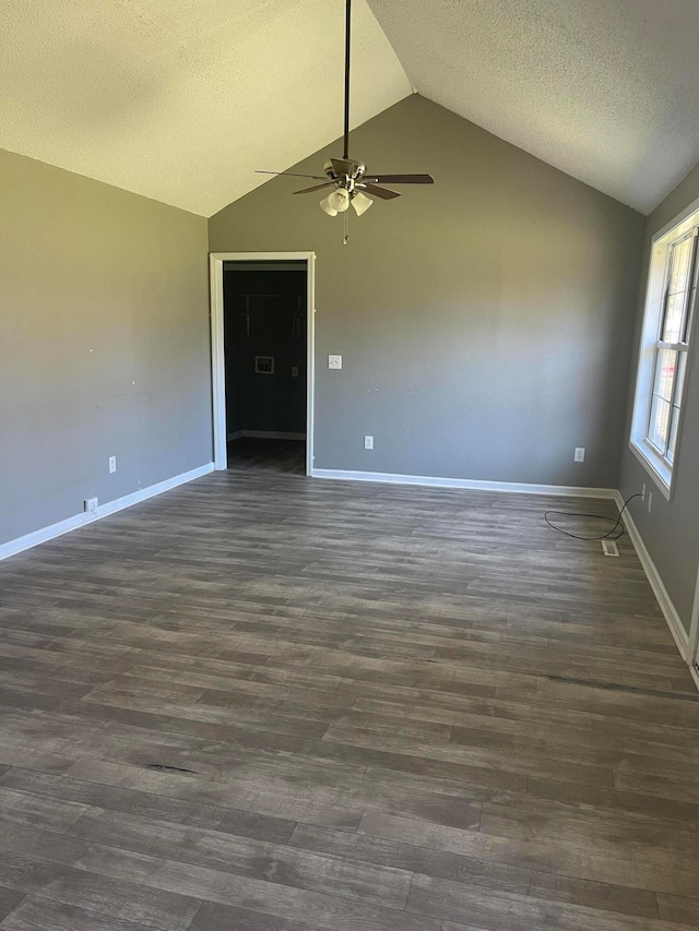 spare room featuring dark hardwood / wood-style floors, ceiling fan, lofted ceiling, and a textured ceiling