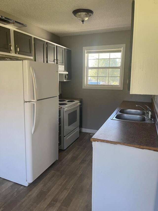 kitchen with sink, dark hardwood / wood-style flooring, ventilation hood, a textured ceiling, and white appliances