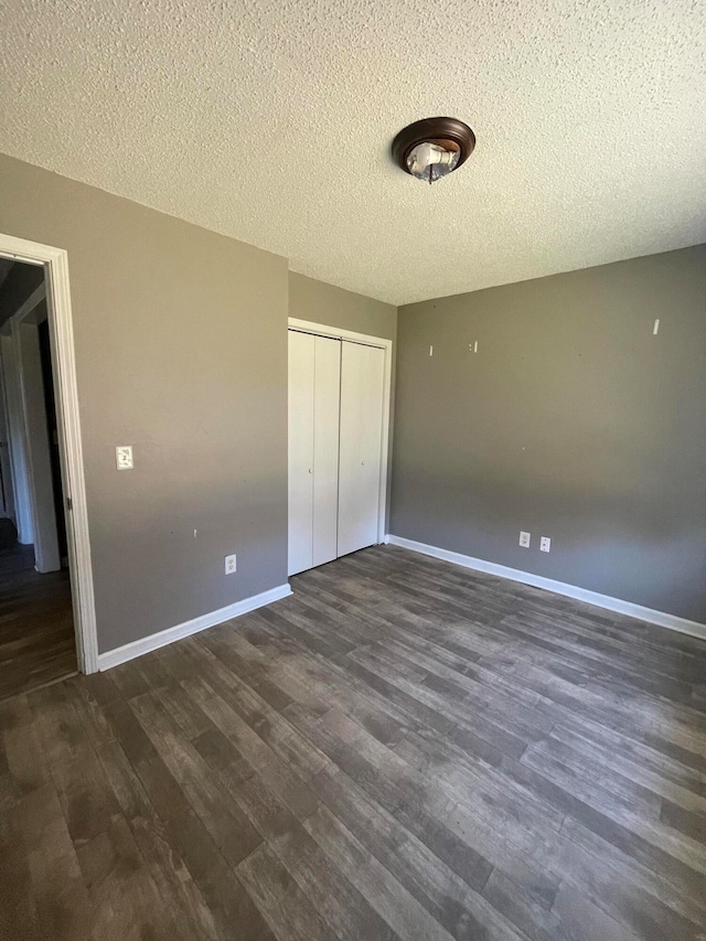 unfurnished bedroom featuring a closet, dark hardwood / wood-style flooring, and a textured ceiling