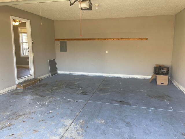 garage featuring electric panel, ceiling fan, and a garage door opener