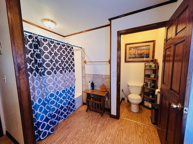 bathroom with toilet, ornamental molding, shower / tub combo, and hardwood / wood-style flooring