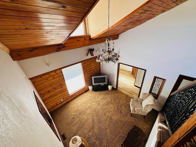 carpeted living room with a healthy amount of sunlight, a chandelier, wooden ceiling, and a high ceiling