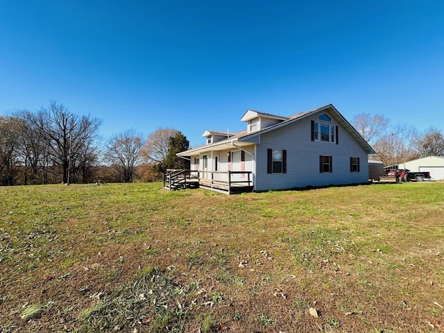 view of side of home featuring a lawn and covered porch