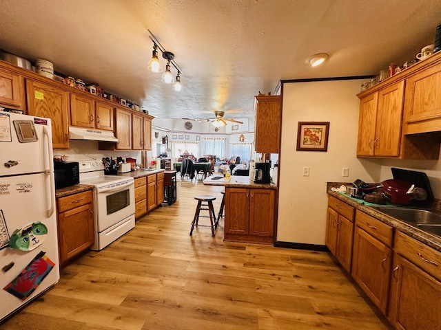 kitchen featuring white appliances, crown molding, ceiling fan, a textured ceiling, and light hardwood / wood-style floors