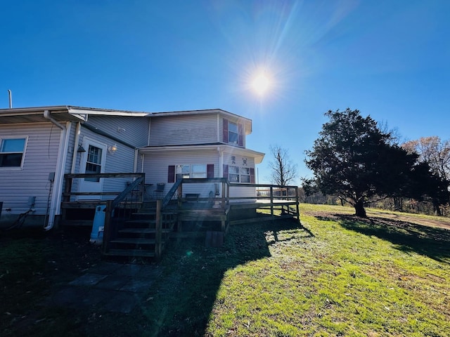 back of property featuring a lawn and a wooden deck