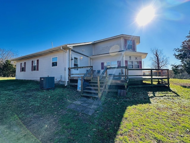 rear view of property with a wooden deck, a yard, and cooling unit