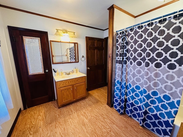 bathroom with hardwood / wood-style flooring, vanity, and ornamental molding