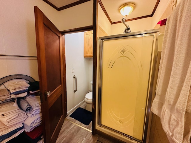 bathroom featuring toilet, wood-type flooring, ornamental molding, and walk in shower