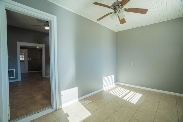 tiled empty room featuring ceiling fan and wooden ceiling