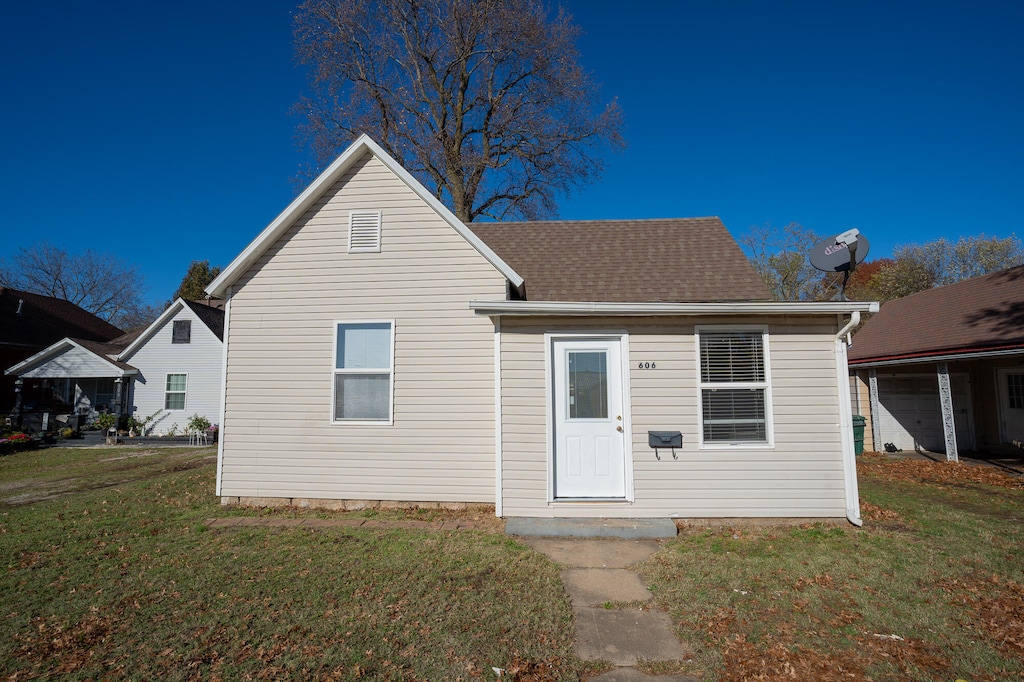 rear view of property with a yard