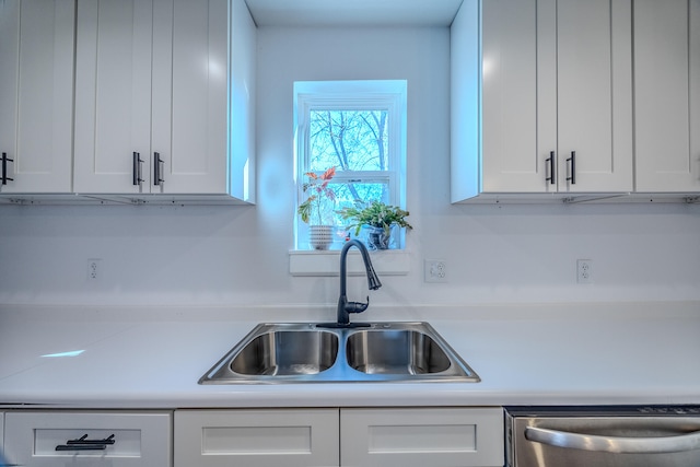 kitchen with white cabinets, dishwasher, and sink