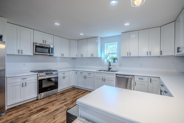 538 W Mack Rd, Seymour, MO 65746 - kitchen with stainless steel appliances, a sink, white cabinets, wood finished floors, and recessed lighting