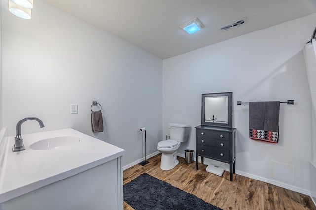 bathroom with hardwood / wood-style floors, vanity, and toilet