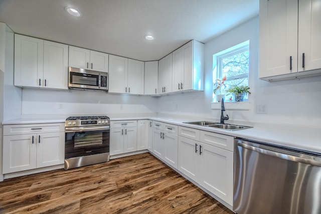 kitchen featuring dark wood-type flooring, white cabinetry, sink, and stainless steel appliances