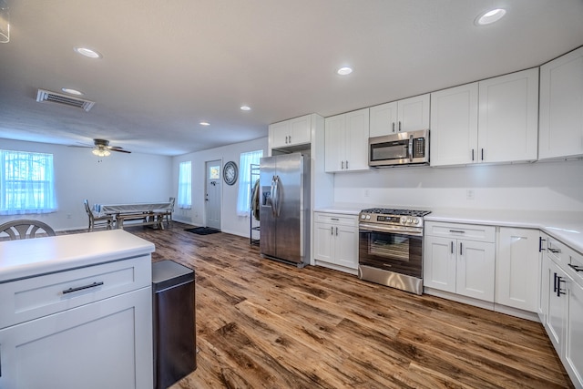 kitchen with a wealth of natural light, white cabinetry, and appliances with stainless steel finishes