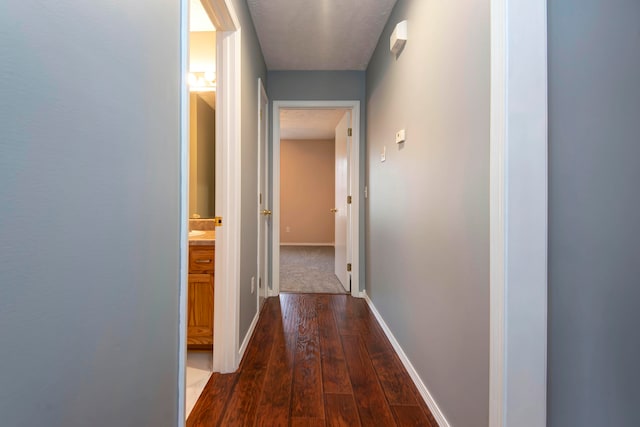 hallway featuring dark hardwood / wood-style floors and a textured ceiling