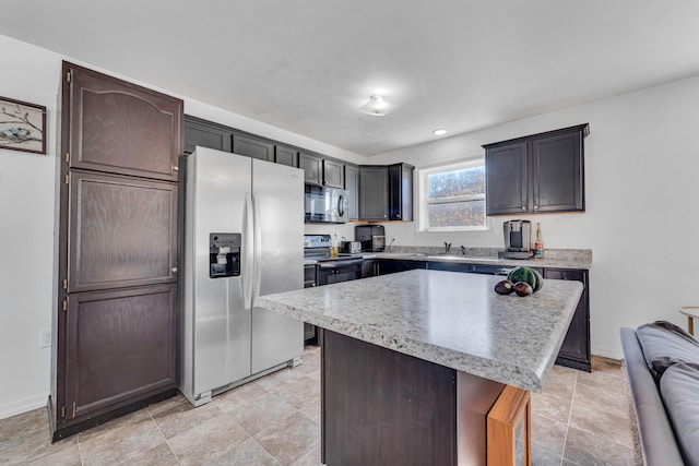 kitchen with dark brown cabinets, stainless steel appliances, and a kitchen island