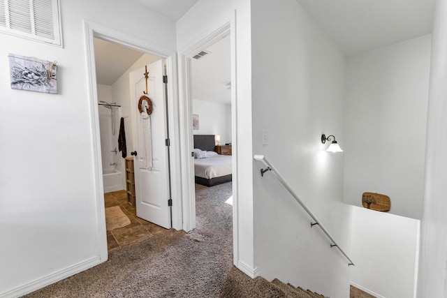 corridor featuring dark colored carpet