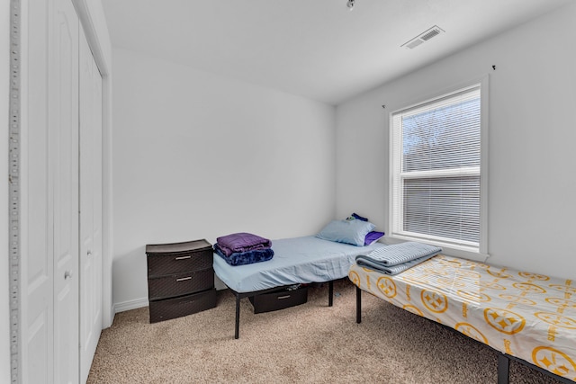 bedroom featuring light colored carpet and a closet