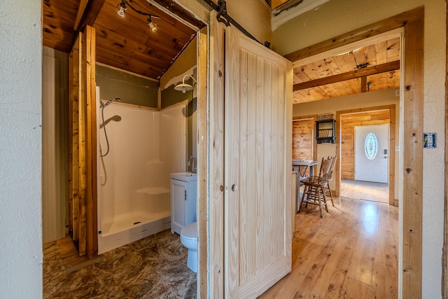 bathroom with a shower, wood-type flooring, toilet, and wooden ceiling