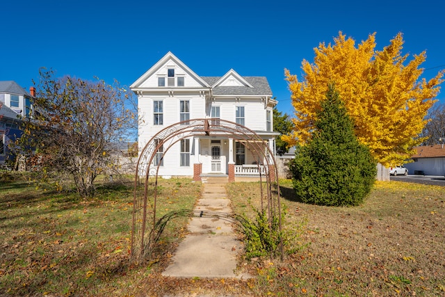 victorian-style house with covered porch and a front lawn