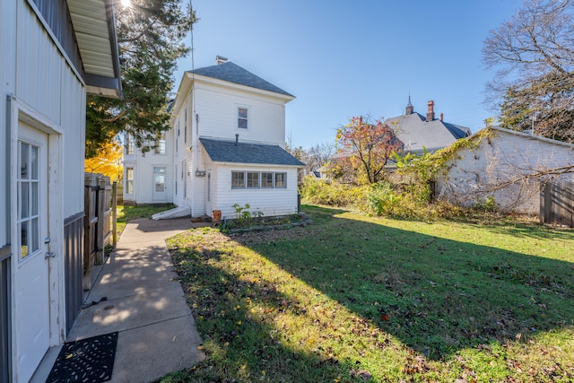 rear view of house featuring a lawn