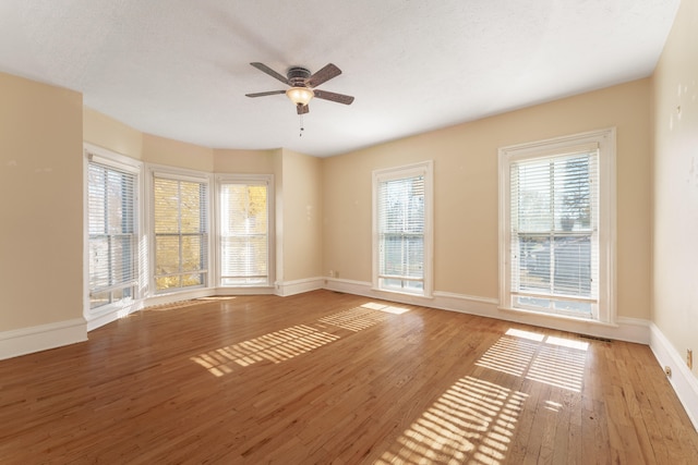 unfurnished room featuring ceiling fan, light wood-type flooring, and a textured ceiling