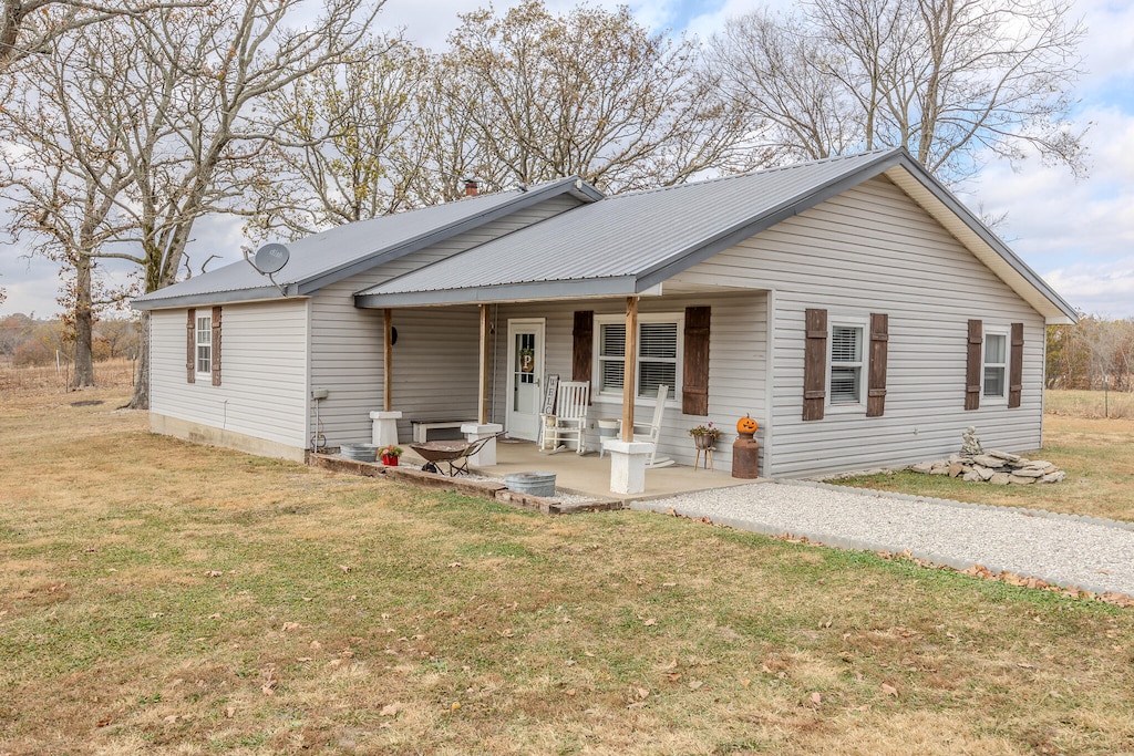 single story home featuring a porch and a front lawn