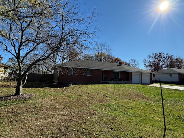 ranch-style home with a garage and a front lawn