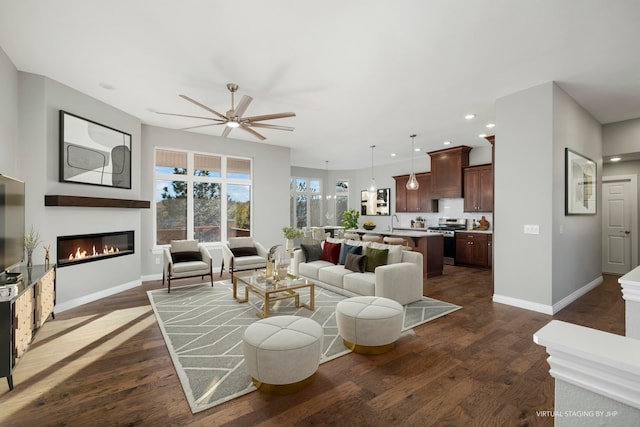 living room featuring dark hardwood / wood-style flooring, ceiling fan, and sink