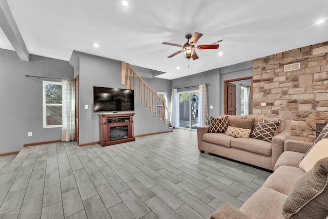 living room featuring light hardwood / wood-style floors, ceiling fan, and a healthy amount of sunlight