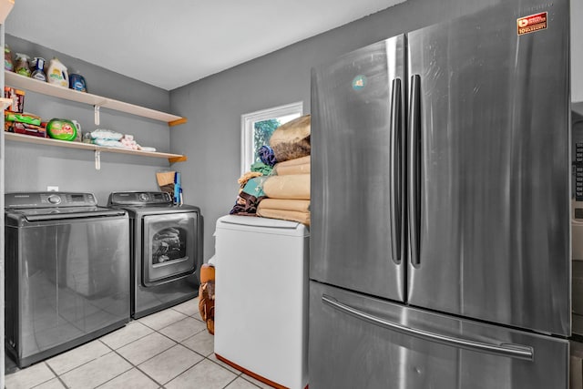 washroom featuring independent washer and dryer and light tile patterned floors