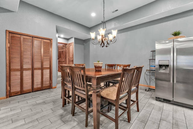 dining space with light hardwood / wood-style flooring and an inviting chandelier