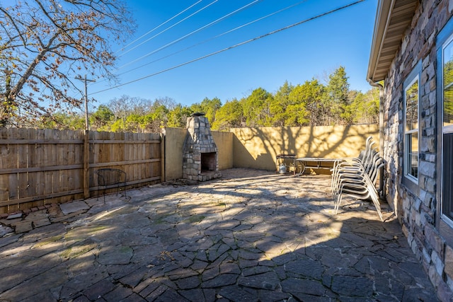 view of patio with an outdoor stone fireplace