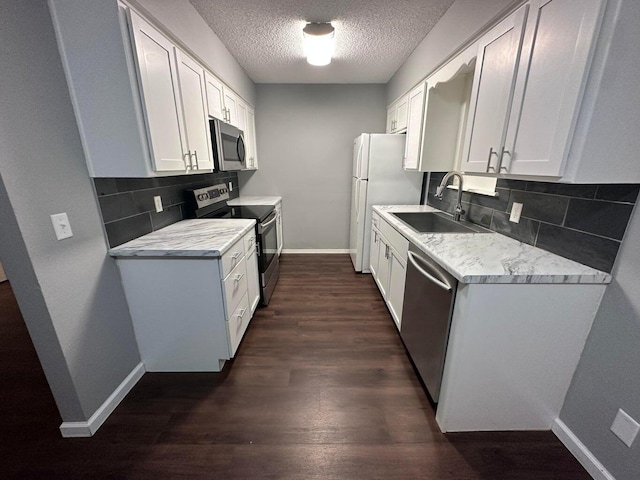 kitchen featuring white cabinets, dark hardwood / wood-style flooring, appliances with stainless steel finishes, and tasteful backsplash