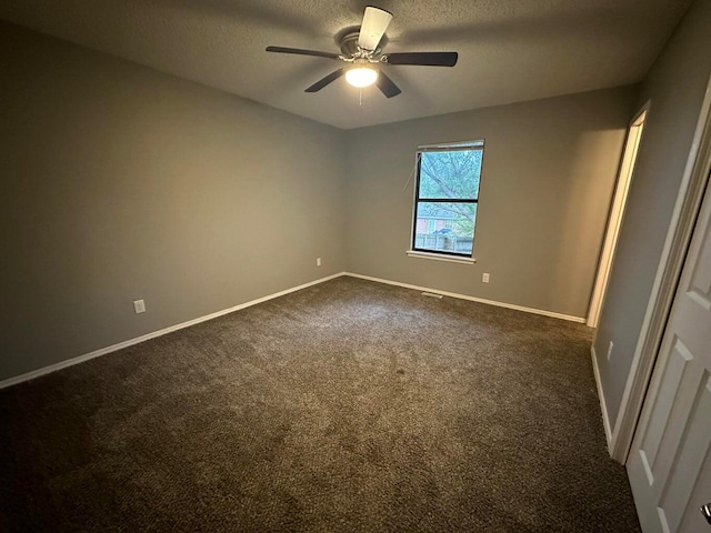 carpeted spare room with a textured ceiling and ceiling fan