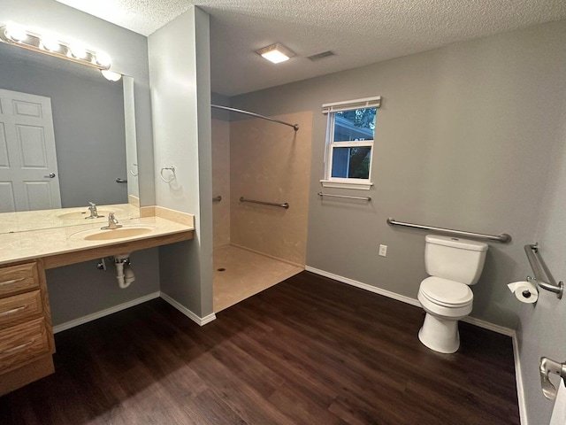 bathroom featuring sink, a shower, wood-type flooring, a textured ceiling, and toilet