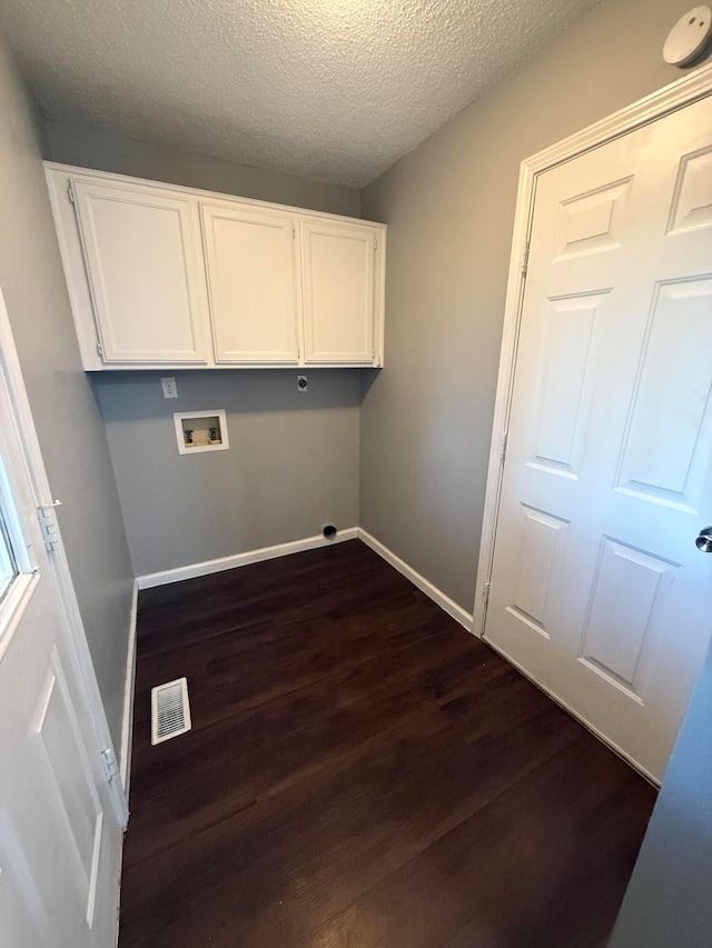 laundry area featuring cabinets, a textured ceiling, dark hardwood / wood-style flooring, and hookup for a washing machine