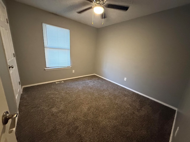 carpeted spare room with ceiling fan and a textured ceiling