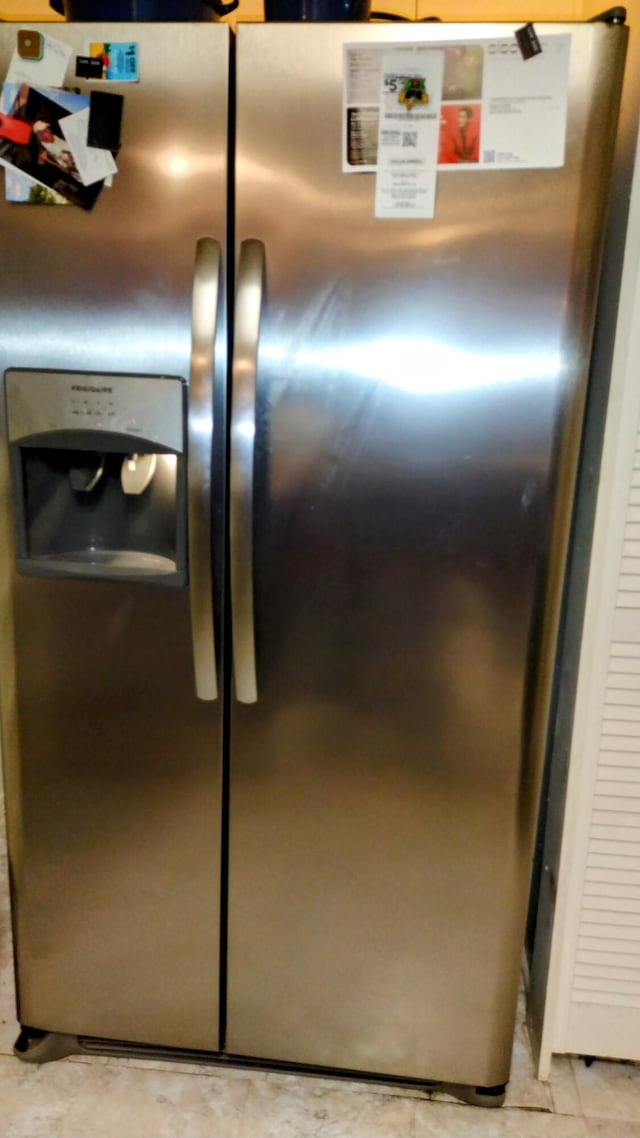 details featuring stainless steel fridge with ice dispenser