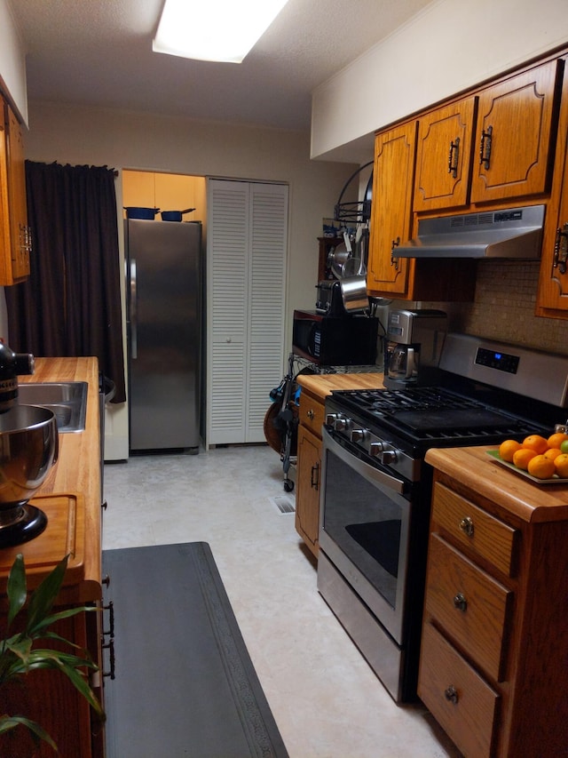 kitchen with backsplash, sink, and appliances with stainless steel finishes