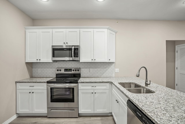 3008 N Vineyards Ter Unit 5, Branson, MO 65616 - kitchen featuring appliances with stainless steel finishes, a sink, light wood-style floors, white cabinetry, and tasteful backsplash