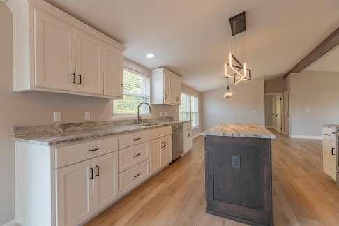 kitchen featuring white cabinetry, decorative light fixtures, light hardwood / wood-style flooring, and a center island