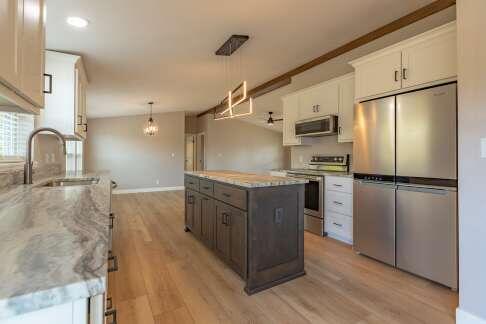 kitchen featuring pendant lighting, appliances with stainless steel finishes, sink, and white cabinets