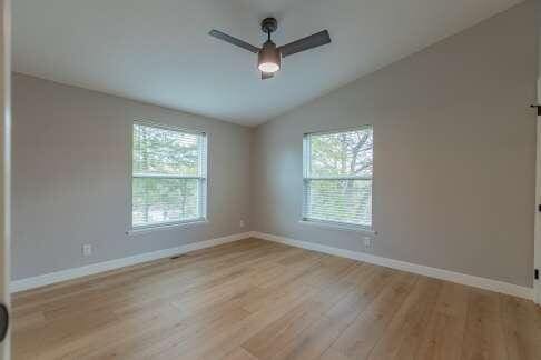 spare room with ceiling fan, lofted ceiling, and light hardwood / wood-style flooring