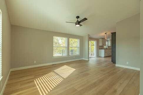 unfurnished living room with hardwood / wood-style flooring and ceiling fan