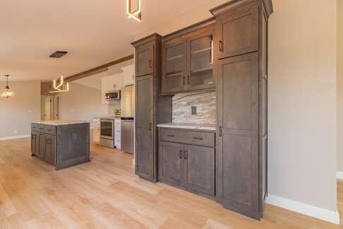 kitchen with a kitchen island, dark brown cabinets, light wood-type flooring, and decorative light fixtures