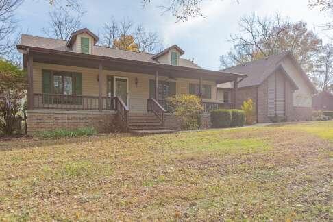 view of front of property featuring covered porch and a front lawn